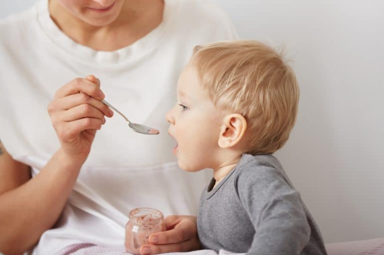 mother feeding her baby boy with spoon Διατροφη